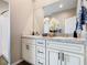 Bathroom with dual sinks, a large mirror, and white cabinets, offering lots of storage at 481 Kensington View Dr, Winter Haven, FL 33880
