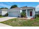 Beautiful single-story home with a well-kept lawn, red accents and an attached two-car garage at 481 Kensington View Dr, Winter Haven, FL 33880