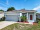 Well maintained single story home with lush landscaping, a two car garage and red accents at 481 Kensington View Dr, Winter Haven, FL 33880