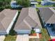 Aerial view of a home with a two-car garage, well-kept lawn, and nicely landscaped front yard at 481 Kensington View Dr, Winter Haven, FL 33880