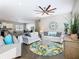 Spacious living area with abundant natural light, modern ceiling fan, comfortable seating, and seamless flow to the kitchen at 481 Kensington View Dr, Winter Haven, FL 33880