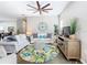 Bright and airy living room with modern ceiling fan, decor rug, and comfortable seating, perfect for relaxing and entertaining at 481 Kensington View Dr, Winter Haven, FL 33880