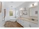 Bathroom with standalone tub, double sinks, white cabinets, and modern lighting at 505 Adams View Ln, Auburndale, FL 33823