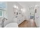 Bathroom with standalone tub, double sinks, white cabinets, and modern lighting at 505 Adams View Ln, Auburndale, FL 33823