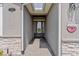 Covered front entry with stone accents and decorative welcome decor at 505 Adams View Ln, Auburndale, FL 33823