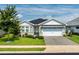 A beautiful single-story home featuring a well-manicured lawn and a large driveway leading to the garage at 505 Adams View Ln, Auburndale, FL 33823