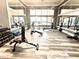 Bright community gym with exercise bikes, weight machines, dumbbells, benches, mirrors and light wood-look floors at 505 Adams View Ln, Auburndale, FL 33823