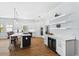 A bright, white kitchen with stainless steel appliances, a central island, and light wood flooring at 505 Adams View Ln, Auburndale, FL 33823