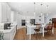 Bright kitchen features white cabinets, hardwood flooring, stainless appliances, and a central island with seating at 505 Adams View Ln, Auburndale, FL 33823