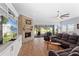 A cozy living room with a fireplace, built-in shelves, and a view to the backyard through large windows at 505 Adams View Ln, Auburndale, FL 33823