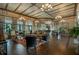 Spacious community lounge area with high ceilings, wood floors, elegant chandeliers, seating, and large windows at 505 Adams View Ln, Auburndale, FL 33823