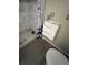 Bathroom featuring a white cabinet sink, a shower with white marble-style tile, and gray flooring at 507 Avenue H Se, Winter Haven, FL 33880