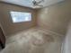 Bedroom with neutral walls and floors, ceiling fan, and one window at 507 Avenue H Se, Winter Haven, FL 33880