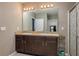 Bathroom featuring double sinks, dark cabinets, and a large mirror at 536 Squires Grove Dr, Winter Haven, FL 33880