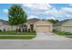 Charming single-story home featuring a manicured lawn, mature tree, and a two-car garage at 536 Squires Grove Dr, Winter Haven, FL 33880