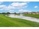 Scenic pond with fountains surrounded by green grass in a residential community at 536 Squires Grove Dr, Winter Haven, FL 33880