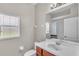 Bright bathroom featuring a large mirror, a single sink vanity, and natural light from the window at 6528 Sedgeford Dr, Lakeland, FL 33811