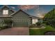 Inviting home exterior features a brick driveway, a two-car garage, and well-maintained landscaping at 6528 Sedgeford Dr, Lakeland, FL 33811