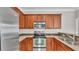 Close-up of kitchen with stainless steel appliances, granite countertops, and dark wood cabinets at 6528 Sedgeford Dr, Lakeland, FL 33811