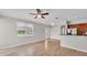 Open living room with wood floors, ceiling fan, bright window, and view of the kitchen at 6528 Sedgeford Dr, Lakeland, FL 33811