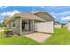 Backyard patio with brick pavers, green grass, a white fence, and a sliding glass door at 6528 Sedgeford Dr, Lakeland, FL 33811