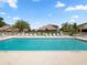 Community pool with plenty of lounge chairs and a view of the clubhouse and residential homes at 6528 Sedgeford Dr, Lakeland, FL 33811