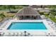 Aerial view of a community pool with chairs, tables, fencing, and a clubhouse at 6528 Sedgeford Dr, Lakeland, FL 33811