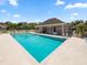Community pool and clubhouse area features lounge chairs and shady sitting areas to relax and enjoy the sun at 6528 Sedgeford Dr, Lakeland, FL 33811