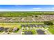 A sprawling aerial view shows uniform houses in a community against a backdrop of lush greenery and blue skies at 716 Vittorio Dr, Winter Haven, FL 33884