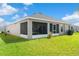 Spacious backyard featuring a screen patio, lush grass, and mature landscaping at 716 Vittorio Dr, Winter Haven, FL 33884