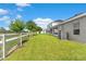 Expansive backyard featuring lush grass and mature landscaping, with a white fence adding charm at 716 Vittorio Dr, Winter Haven, FL 33884