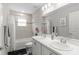 Bright bathroom featuring double sinks, large mirror, and tiled shower at 716 Vittorio Dr, Winter Haven, FL 33884