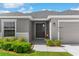 Inviting front entrance with gray door, tidy landscaping, and a glimpse of the home's exterior features at 716 Vittorio Dr, Winter Haven, FL 33884