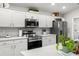 Updated kitchen showcasing stainless steel appliances, white cabinets, and quartz countertops at 716 Vittorio Dr, Winter Haven, FL 33884