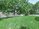 A spacious and well-maintained backyard with lush green grass, mature trees, and a white fence at 7714 Chase Rd, Lakeland, FL 33810