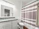 Bathroom with a granite vanity, white cabinets, a mirror, and a shower with a striped curtain at 7714 Chase Rd, Lakeland, FL 33810