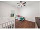 Bright bedroom featuring hardwood floors, a ceiling fan, and a twin bed at 7714 Chase Rd, Lakeland, FL 33810