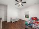 Bright bedroom featuring a crib, ceiling fan, and window with natural light at 7714 Chase Rd, Lakeland, FL 33810