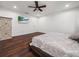 Bright bedroom with hardwood floors, ceiling fan, and a decorative armoire at 7714 Chase Rd, Lakeland, FL 33810