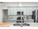 This kitchen features light blue cabinets, stainless steel appliances, and mosaic tile backsplash at 7714 Chase Rd, Lakeland, FL 33810