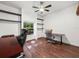 Office space featuring wood floors, a ceiling fan, a window, floating shelves, and office furniture at 7714 Chase Rd, Lakeland, FL 33810