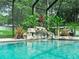 Screened pool area featuring lush tropical landscaping and a rock waterfall feature at 7714 Chase Rd, Lakeland, FL 33810