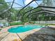 Enclosed pool with a waterfall feature and landscaped surroundings at 7714 Chase Rd, Lakeland, FL 33810