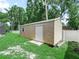 Backyard shed with a white door and window, nestled in a well-kept grassy area at 7714 Chase Rd, Lakeland, FL 33810
