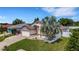 Charming home with a two-car garage, stone accents, manicured lawn, and mature palm tree at 7929 Ashley Pointe Dr, Lakeland, FL 33810