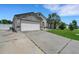Charming home with a two-car garage, stone accents, driveway, manicured lawn, and beautiful palm tree at 7929 Ashley Pointe Dr, Lakeland, FL 33810