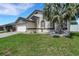 Charming exterior showcasing a well-maintained lawn, stone accents, and decorative landscaping at 7929 Ashley Pointe Dr, Lakeland, FL 33810