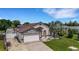 Charming home with a two-car garage, stone accents, driveway, manicured lawn, and beautiful palm tree at 7929 Ashley Pointe Dr, Lakeland, FL 33810