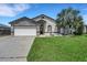 Charming home with stone accents, a two-car garage, a well-maintained lawn, and a beautiful palm tree at 7929 Ashley Pointe Dr, Lakeland, FL 33810
