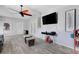 Spacious living room featuring a large ceiling fan, hard surface floors, and a mounted television at 7929 Ashley Pointe Dr, Lakeland, FL 33810
